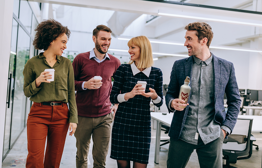 Four people with drinks in hand at the UniS building
